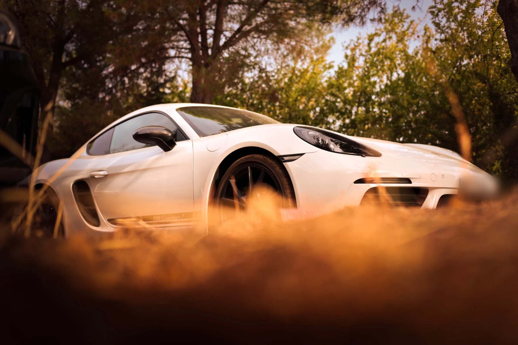 Low front three-quarter view of a white Porsche 718 Cayman T